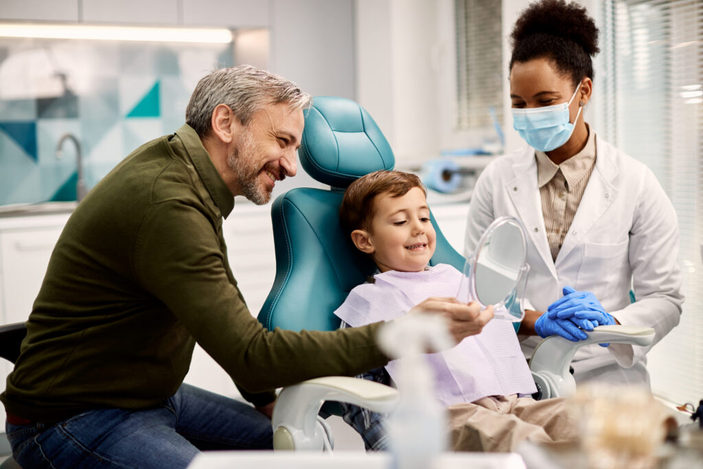 Child at an orthodontic observation visit with a parent reviewing smile progress in the dental chair